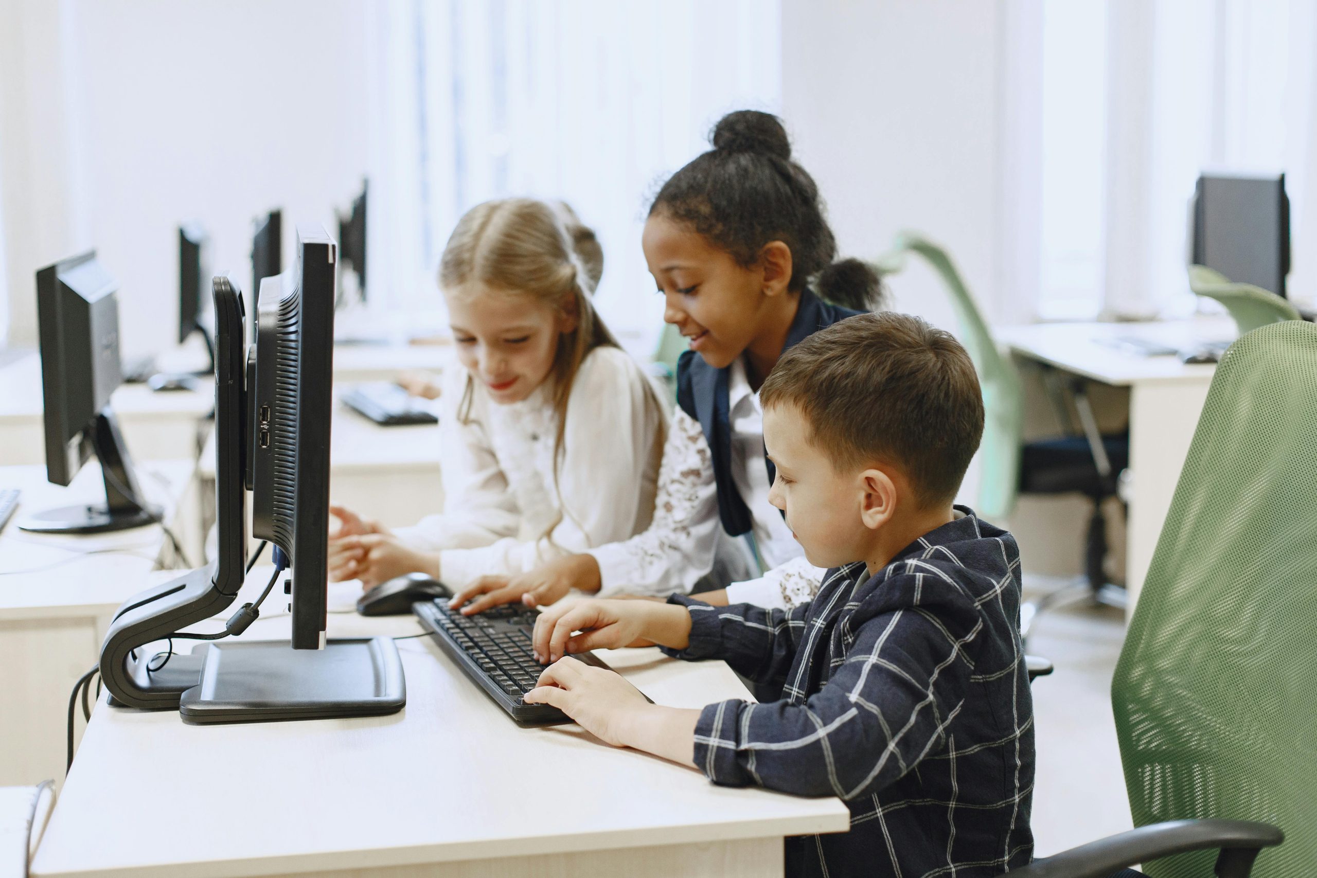 Three kids sitting in front of a computer