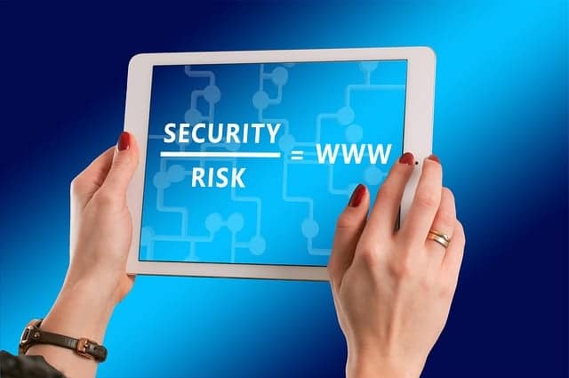 Woman holding tablet with "security" over "risk" equals "www"